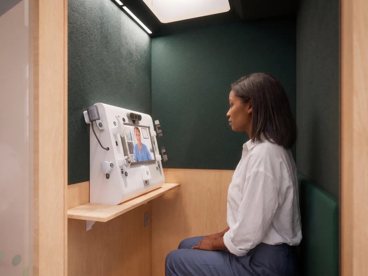 A patient consulting a licensed doctor on a Tessan telehealth console inside a partner pharmacy.