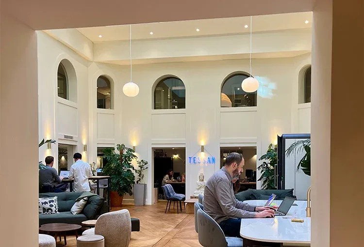 Tessan's Paris office, a bright open lounge with tall arched windows.