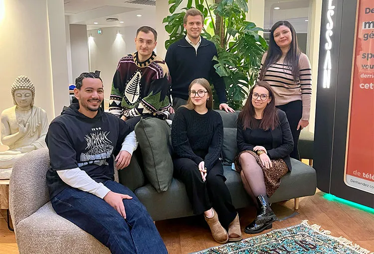 Six members of the Tessan team together on a couch in the office lounge.